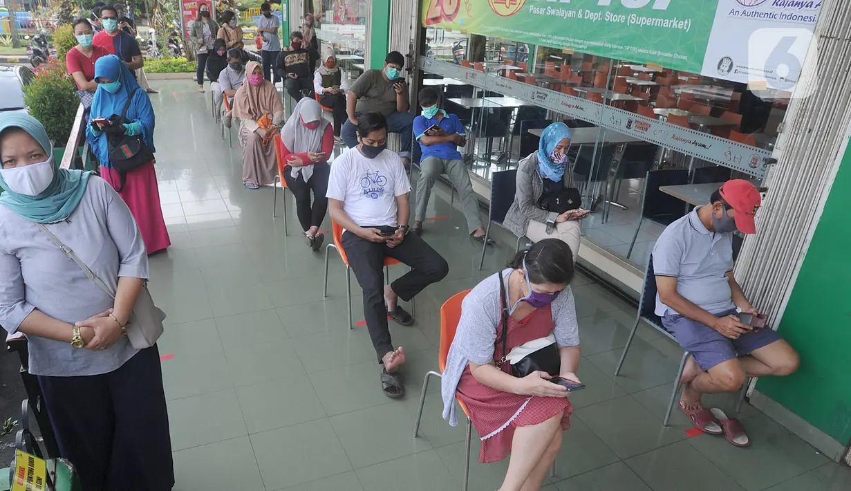 Pengunjung antre dengan menjaga jarak fisik (Physical Distancing) saat menunggu supermarket buka di kawasan Ciputat, Tangerang Selatan, Selasa (14/4/2020). Pemerintah terus mengimbau warga untuk melakukan jarak fisik sebagai tindakan pencegahan penyebaran Corona COVID-19. (merdeka.com/Arie Basuki)