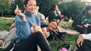 Duduk santai di taman menikmati hari ala Enzy Storia. Dengan atasan turtleneck rajut berwarna biru, dipadu dengan legging panjang berwarna hitam, gaya kasual Enzy dilengkapi dengan sunglasses, kaus kaki panjang, dan sneakers putih. Foto: Instagram.