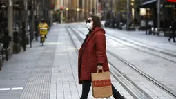 Seorang perempuan melintasi jalan yang biasanya sibuk di Sydney, pada Rabu (7/7/2021). Lockdown covid-19 selama dua pekan di Sydney telah diperpanjang seminggu lagi hingga 16 Juli karena kerentanan populasi Australia yang sebagian besar belum divaksinasi, kata para pejabat. (AP Photo/Rick Rycroft)