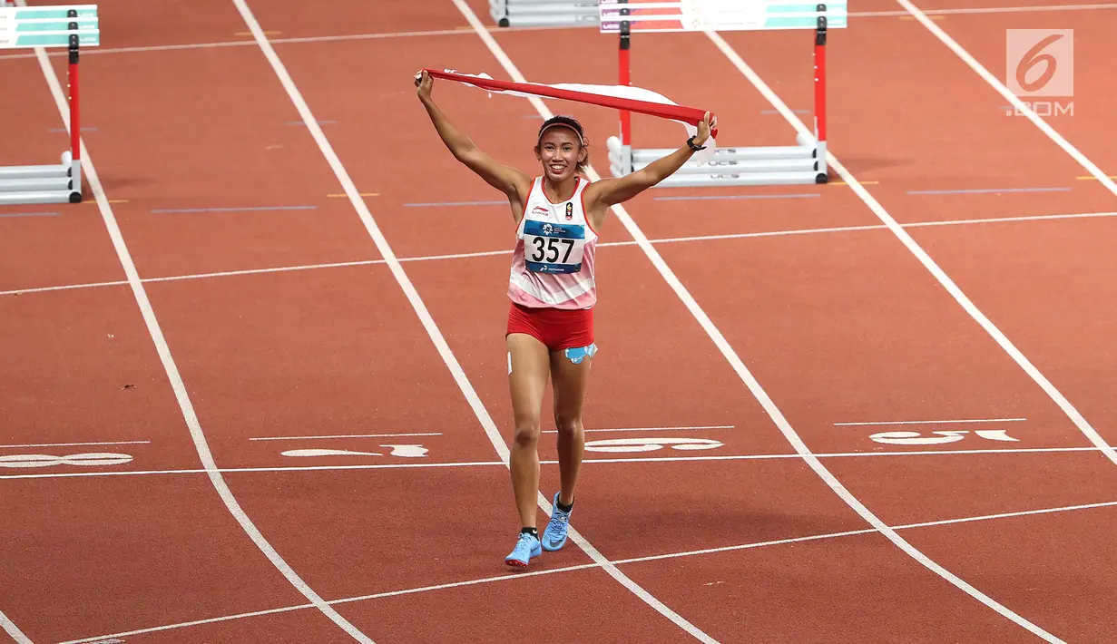 Pelari Indonesia, Nova Emilia membawa bendera merah putih usai finis di urutan kedua setelah pelari Korea Selatan Jung Hyelim pada final atletik nomor lari halang rintang 100 meter putri di Stadion Utama GBK, Jakarta (26/8). (Liputan6.com/Fery Pradolo)