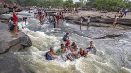 Orang-orang bermain di perairan Air Terjun Rajdari pada hari musim panas yang terik di distrik Chandauli, negara bagian Uttar Pradesh, India (28/6/2021).  Air Terjun Rajdari adalah tempat piknik yang populer bagi orang-orang di sekitar area tersebut pada musim panas. (AP Photo/Rajesh Kumar Singh)