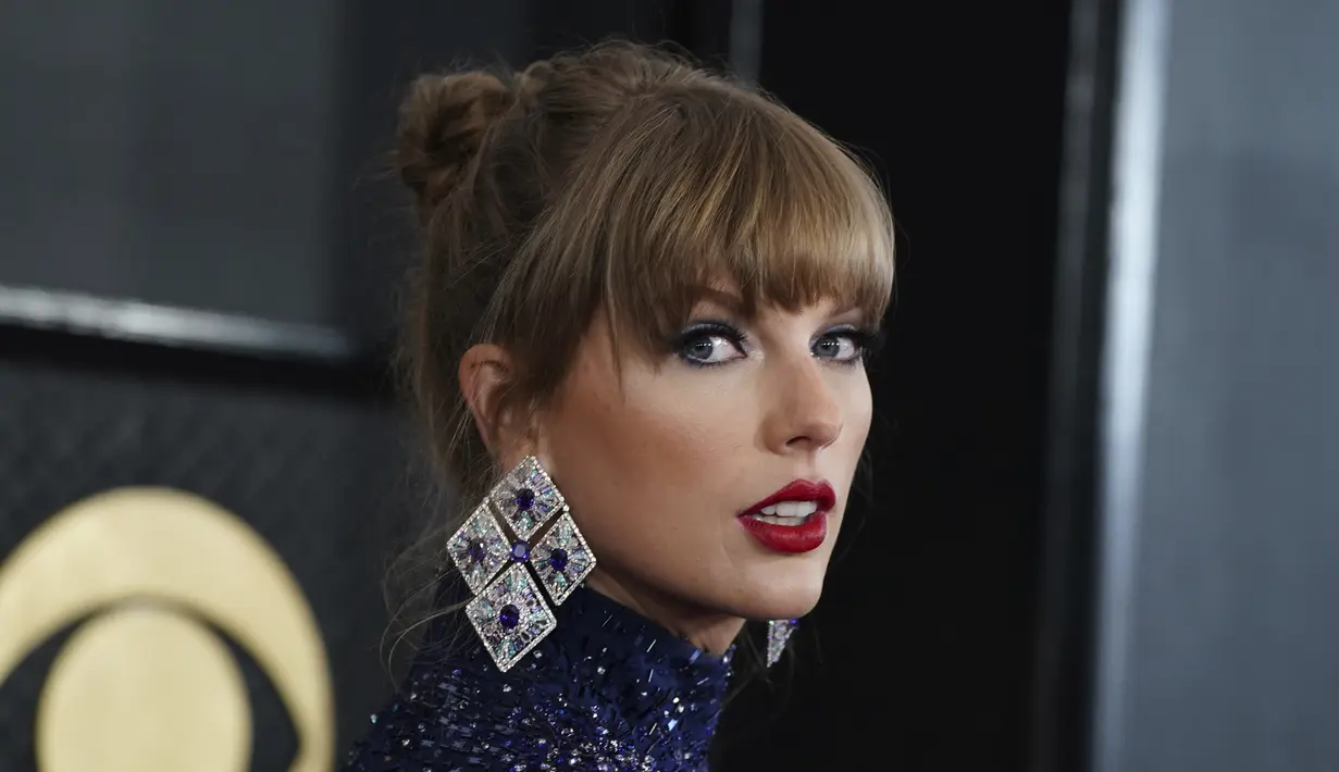Taylor Swift berpose untuk fotografer di karpet merah ajang Grammy Awards 2023 di Crypto.com Arena, Los Angeles, AS, Senin (6/2/2023) pagi waktu Indonesia. Penampilannya terlihat semakin glamor dengan perhiasan berlian yang mencengangkan, serta anting-anting batu permata Lorraine Schwartz, ditambah cincin pernyataan safir dan manikur krom yang serasi. (Photo by Jordan Strauss/Invision/AP)