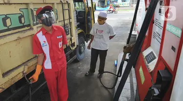 Petugas dengan sarung tangan, masker dan pelindung wajah melayani pembeli BBM di SPBU kawasan Cilendek, Bogor, Selasa (5/5/2020). Mencegah penularan Covid-19, sejumlah perusahaan memberikan pelindung diri kepada pegawai, terlebih yang berhubungan langsung dengan pelanggan. (merdeka.com/Arie Basuki)