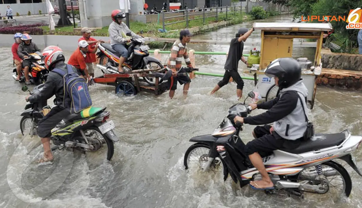 Beberapa pengendara sepeda motor yang melintas tampak menaiki gerobak untuk mencegah air masuk ke dalam mesin (Liputan6.com/Andrian M Tunay)