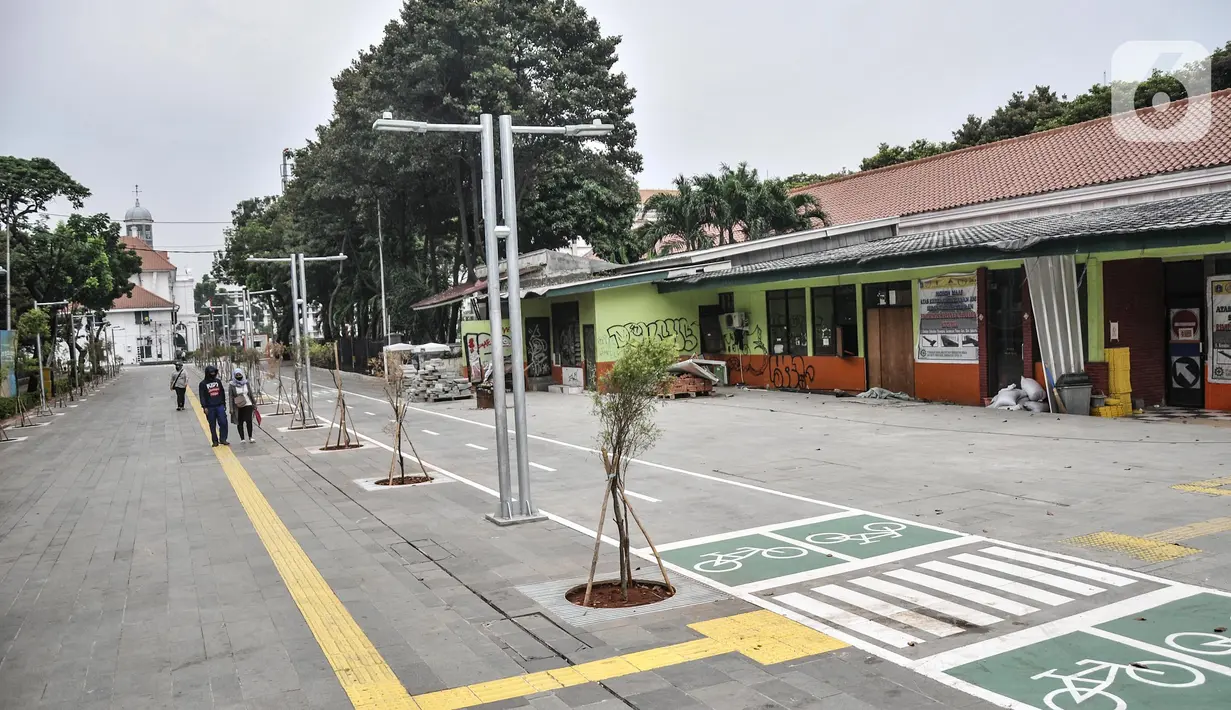 Pejalan kaki melintasi jalur pedestrian yang telah rampung dibangun di kawasan wisata Kota Tua, Jakarta Barat, Senin (22/8/2022). Proyek revitalisasi jalur pedestrian Kota Tua yang diharapkan dapat meningkatkan kenyamanan bagi pejalan kaki dan pengguna sepeda serta mewujudkan kawasan rendah emisi tersebut saat ini telah rampung dikerjakan. Pemprov DKI Jakarta rencananya akan meresmikan jalur pedestrian Kota Tua ini pada akhir Agustus mendatang. (merdeka.com/Iqbal S. Nugroho)