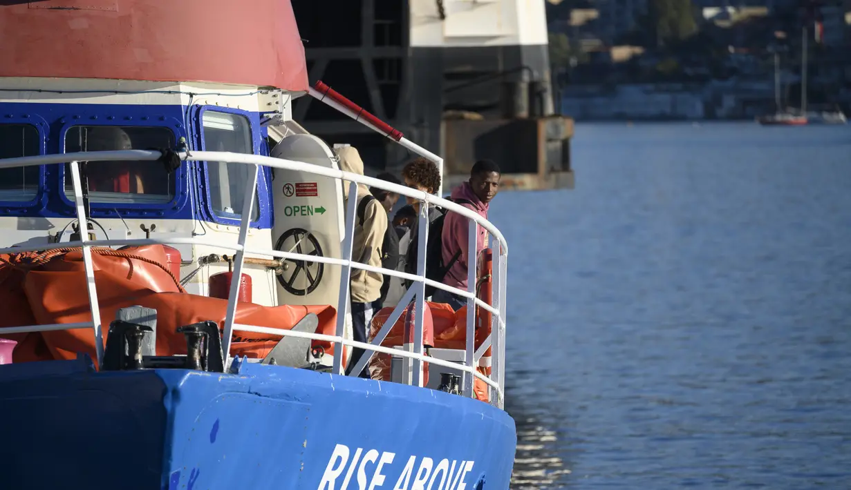 Para migran keluar dari kapal kemanusiaan Jerman Rise Above saat mereka berlabuh di kota pelabuhan Italia selatan Reggio Calabria, Selasa (8/11/2022). Kelompok kemanusiaan Jerman Mission Lifeline mengatakan kapalnya berlabuh di Italia selatan Selasa pagi dan menurunkan 89 orang yang telah diselamatkannya di Mediterania tengah. (AP Photo/Valeria Ferraro)