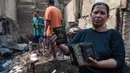 Seorang warga memperlihatkan surat-surat kendaraan bermotor yang hangus terbakar saat kebakaran melanda permukiman di Jalan Kramat Pulo Dalam, Senen, Jakarta Pusat, Jumat (9/10/2026). (KLY/Budy Santoso)