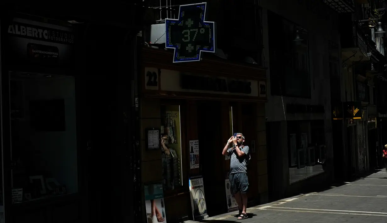 Seseorang mengambil foto di mana apotek menampilkan suhu, 37 derajat Celcius (98,6 Fahrenheit) di Pamplona, Spanyol, 15 Juni 2022. Layanan cuaca Spanyol mengatakan massa udara panas dari Afrika Utara memicu gelombang panas besar pertama di negara itu tahun ini dengan suhu diperkirakan akan meningkat menjadi 43 derajat Celcius (109 derajat Fahrenheit) di area tertentu. (AP Photo/Alvaro Barrientos)