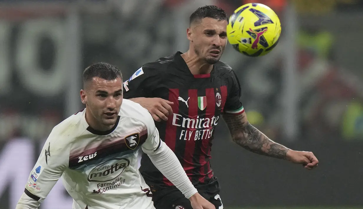 Striker Salernitana, Federico Bonazzoli (kiri) berebut bola dengan gelandang AC Milan, Rade Krunic pada laga pekan ke-26 Liga Italia 2022/2023 di San Siro Stadium, Milan, Selasa (14/3/2023) dini hari WIB. (AP Photo/Luca Bruno)