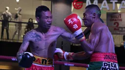 Frans Damur (kiri) melepaskan pukulan kearah Jon Jon Jet pada kelas Flyweight Mahkota Boxing Super Series di Cilandak Town Square, Jakarta (10/3/2018). Jon Jon Jetz menang angka mutalak atas Frans. (Bola.com/Nick Hanoatubun)