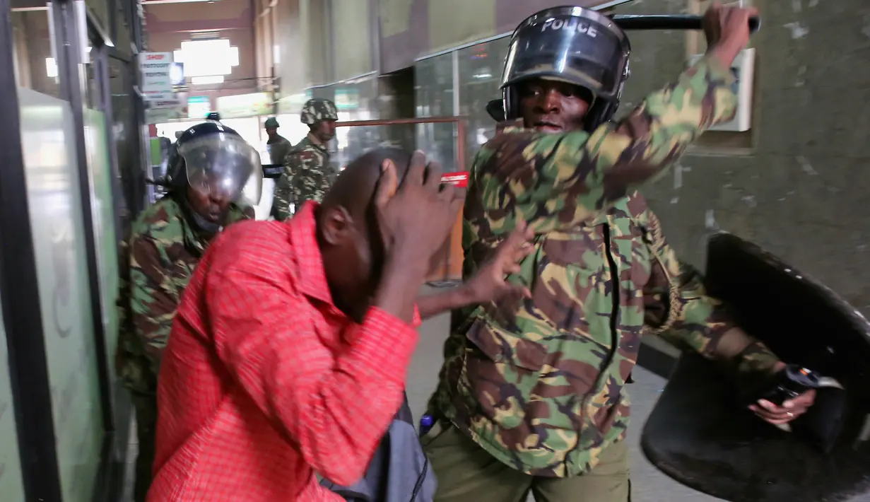 Polisi memukuli seorang demonstran di dalam sebuah gedung saat bentrokan di Nairobi, Kenya (16/5). Demonstran menuntut pembubaran otoritas pemilu karena adanya dugaan korupsi. (REUTERS/Goran (REUTERS/Goran Tomasevic)