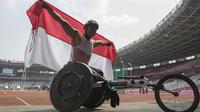 Pebalap kursi roda Indonesia, Jaenal Aripin, melakukan selebrasi usai meraih medali perak pada Asian Para Games cabang atletik nomor balap kursi roda 200 meter T 54 di SUGBK, Jakarta, Jumat (12/10). (Bola.com/Vitalis Yogi Trisna)