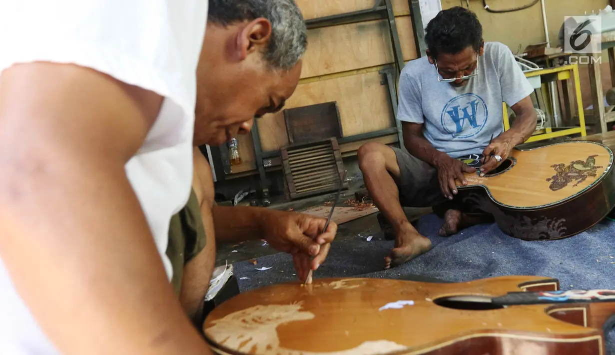 Pekerja tengah mengukir gitar di workshop I Wayan Tuges gitar berlabel Blueberry di Jalan Baruna No. 5 Guwang, Sukowati, Bali, Senin (15/10). Gitar-gitar produksinya itu dibanderol seharga puluhan juta rupiah. (Liputan6.com/Angga Yuniar)