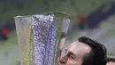 Pelatih Villareal, Unai Emery mencium trofi saat merayakan timnya memenangkan pertandingan melawan Manchester United pada final Piala Europa di Gdansk, Polandia, Kamis (27/5/2021).  Villareal berhak ke Liga Champions musim depan lewat jalur ini, meski di LaLiga finis ketujuh. (Kacper Pempel, Pool vi