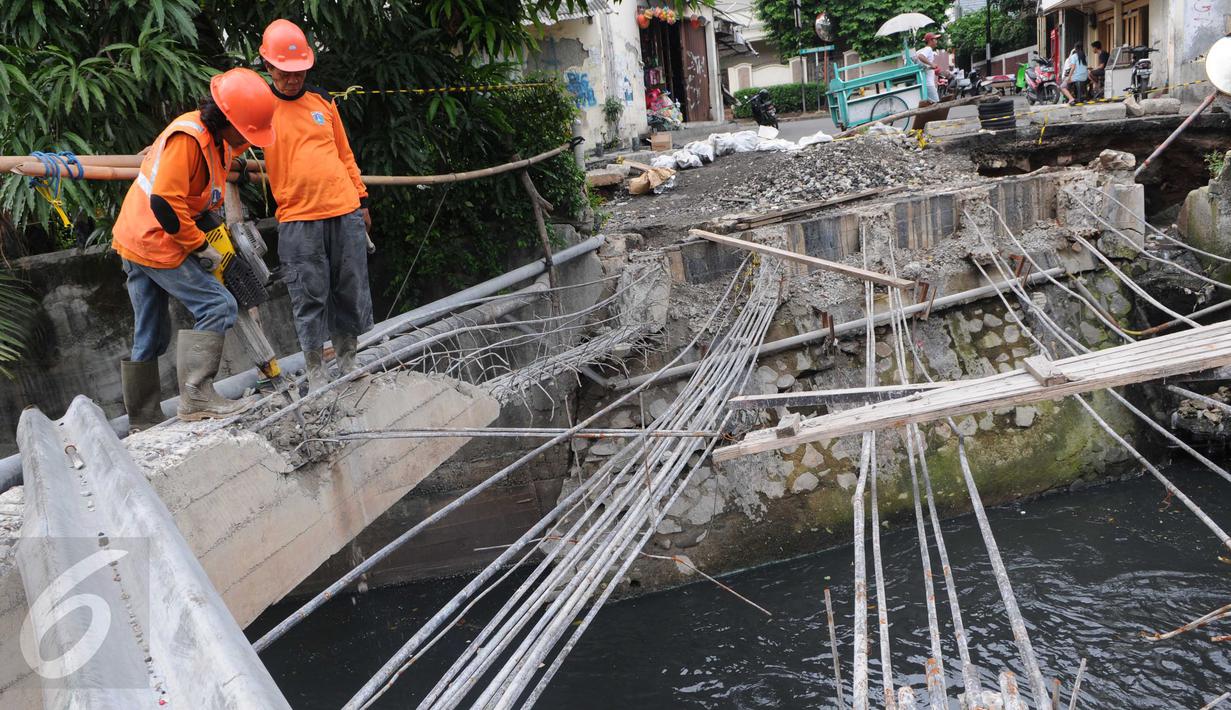 Petugas Suku Dinas Bina Marga Jakarta Barat memperbaiki Jembatan Kali Inspeksi Grogol, Jakarta, (30/5/2016). Pergeseran tanah di bawah Kali Irigasi Grogol sehingga pondasi jembatan bergeser dan permukaan jalan ambles. (Liputan6.com/Helmi Afandi)
