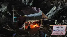 Warga Palestina duduk di tenda yang didirikan di atas reruntuhan bangunan yang hancur dalam serangan udara Israel di Kota Gaza (24/5/2021). Menyusul gencatan senjata yang dicapai setelah perang 11 hari antara Israel dan Hamas, Warga Palestina mendirikan tenda di reruntuhan. (AFP/Mohamed Abed)