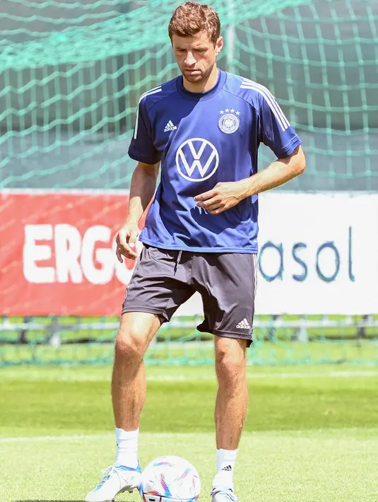 Pemain Jerman Thomas Mueller melakukan pemanasan saat sesi latihan di pusat olahraga BVSC, Budapest, Hungaria, 13 Juni 2022. Jerman akan menghadapi Italia pada pertandingan sepak bola UEFA Nations League. (Attila KISBENEDEK/AFP)
