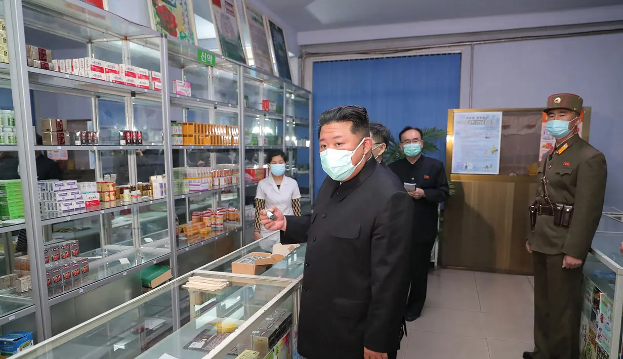 Pemimpin Korea Utara Kim Jong Un mengenakan masker memeriksa apotek di tengah wabah Covid-19 di Pyongyang, Korea Utara pada 15 Mei 2022. Korea Utara telah memobilisasi militernya untuk mendistribusikan obat-obatan COVID dan mengerahkan lebih dari 10.000 petugas kesehatan untuk membantu melacak pasien potensial terkena Covid-19. (STR/KCNA VIA KNS/AFP)