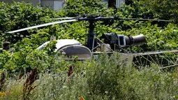 Sebuah helikopter yang ditinggalkan seorang gangster terkenal Prancis, Redoine Faid di Gonesse, utara Paris, Minggu (1/7). Faid kabur dengan bantuan sejumlah pria bersenjata yang mendaratkan helikopter di halaman penjara. (AFP/GEOFFROY VAN DER HASSELT)