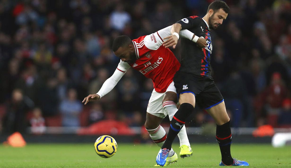 Striker Arsenal, Alexandre Lacazette, berebut bola dengan pemain Crystal Palace, Luka Milivojevic, pada laga Premier League 2019 di Stadion Emirates, Minggu 927/10). Kedua tim bermain imbang 2-2. (AP/Leila Coker)