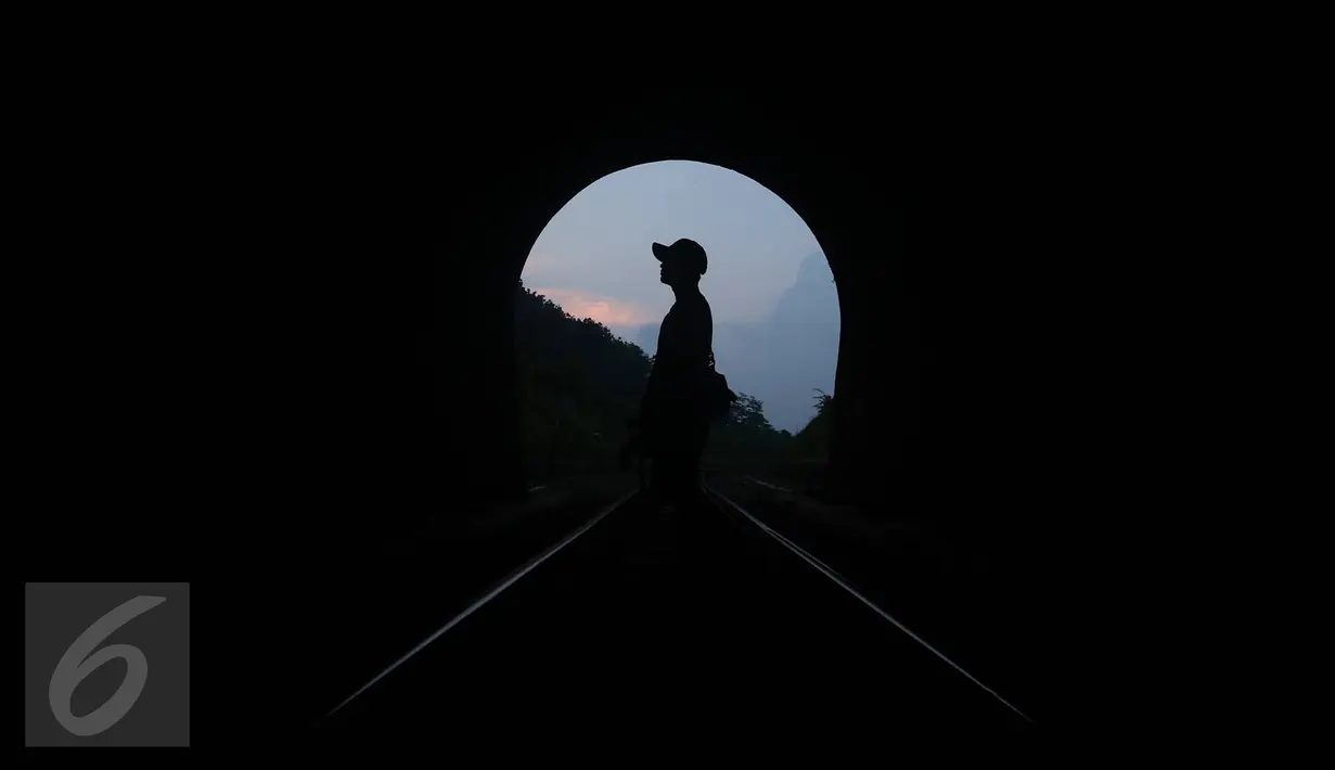 Pengunjung melintasi rel sekitar terowongan Sasaksaat, Bandung Barat, Jawa Barat, Selasa (5/7). Terowongan yang memiliki panjang sekitar 949 meter tersebut menjadi terowongan kereta terpanjang di Indonesia yang masih aktif (Liputan6.com/Immanuel Antonius)