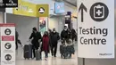 <p>Penumpang tiba di Bandara Heathrow, London, Inggris, Senin (29/11/2021). Para keluarga diminta tetap merayakan Natal "seperti biasa" meski ada pengetatan aturan. (AP Photo/Frank Augstein)</p>