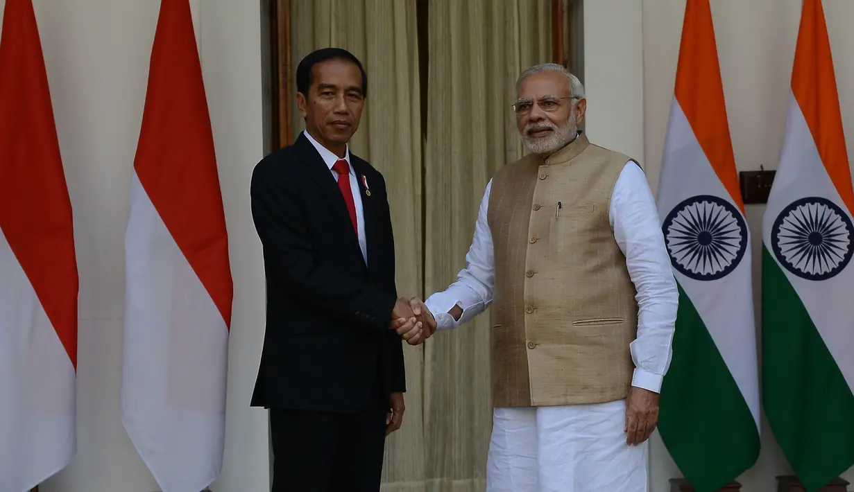Presiden Joko Widodo (Jokowi) berjabat tangan dengan PM India Narendra Modi sebelum melakukan pertemuan bilateral di Hyderabad House, New Delhi, Senin (12/12). Ini pertama kalinya Presiden Jokowi melakukan kunjungan kenegaraan ke India. (Money SHARMA/AFP)