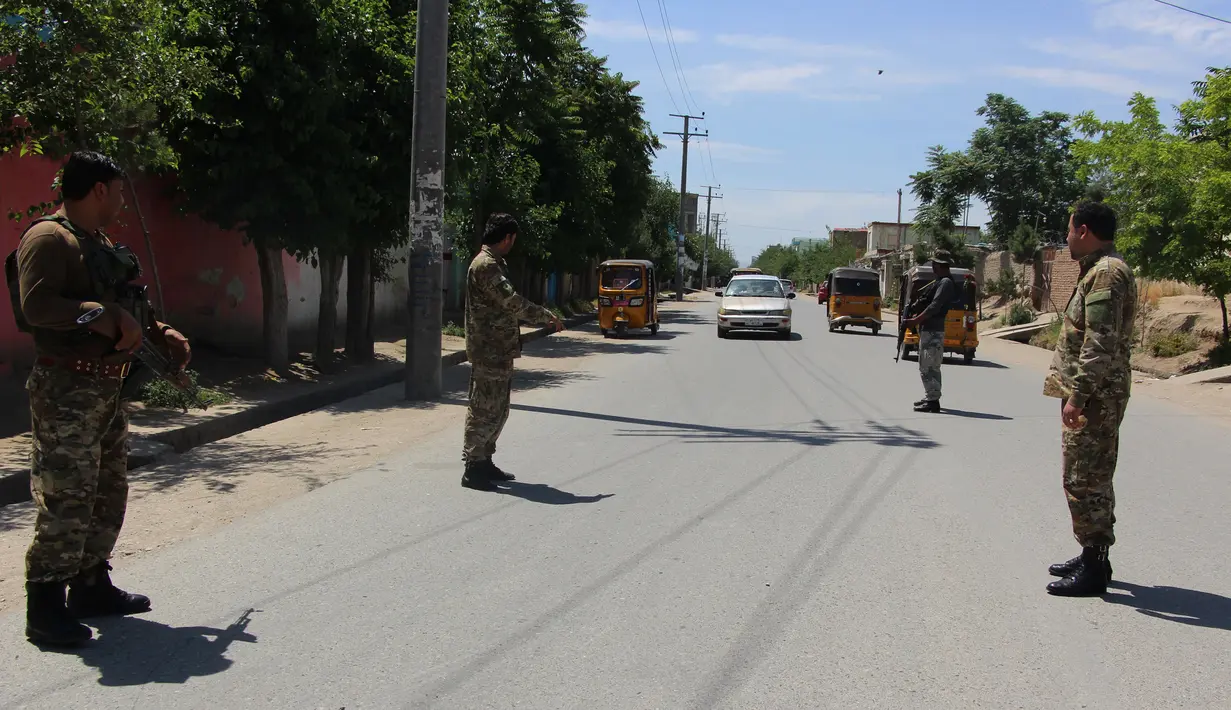 Anggota pasukan keamanan Afghanistan berdiri di sebuah pos pemeriksaan keamanan di Kunduz, Afghanistan, Kamis (21/5/2020). Pasukan keamanan Afghanistan meningkatkan pengamanan menjelang Hari Raya Idul Fitri yang menandai berakhirnya bulan suci Ramadan. (Xinhua/Ajmal Kakar)