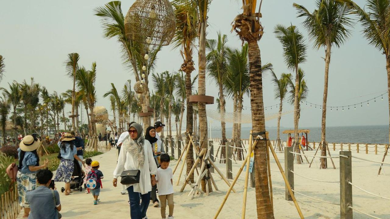 Wisatawan mengunjungi pantai pasir putih dan destinasi kuliner Aloha PIK di kawasan Pantai Indah Kapuk (PIK) 2, Tangerang, Banten, Senin (25/12/2023).&nbsp;Aloha PIK merupakan sebuah destinasi tematik baru yang berlokasi di pantai pasir putih sepanjang em