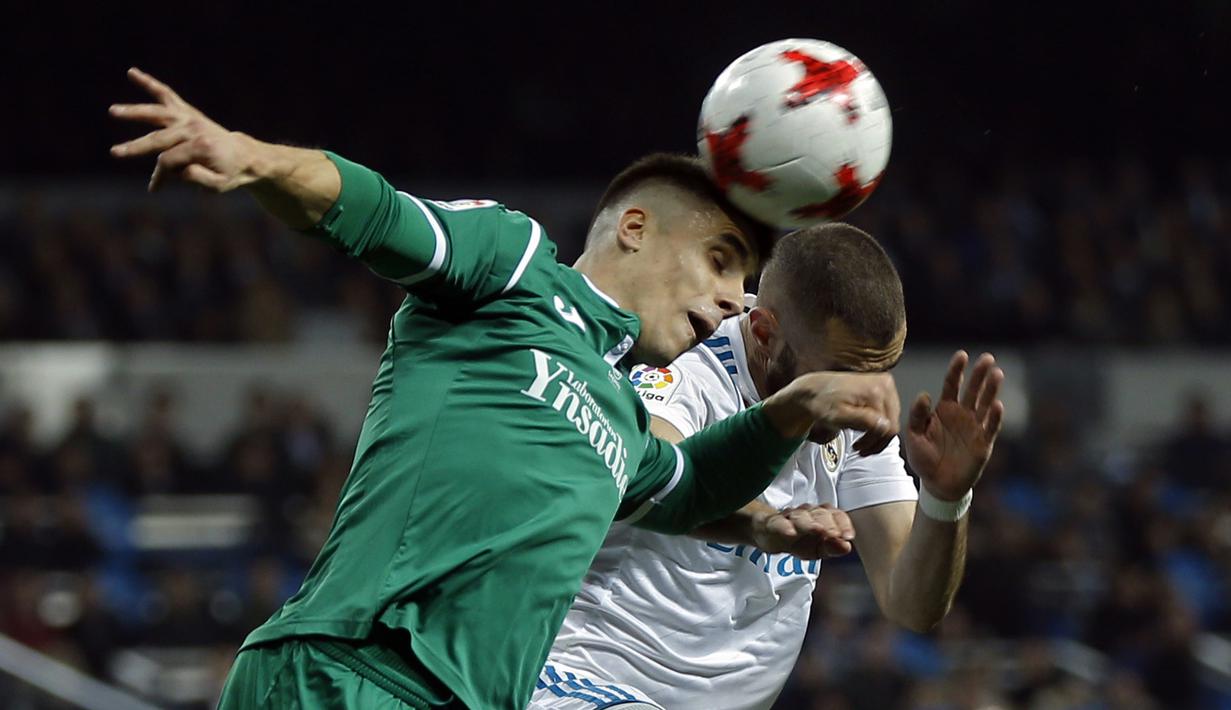 Duel pemain Real Madrid, Karim Benzema (kanan) dan pemain Leganes, Unai Bustinza pada perempat final Copa del Rey di Santiago Bernabeu stadium, Madrid, (24/1/2018). Leganes menang 2-1. (AP/Francisco Seco)
