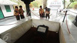 Sejumlah Pramuka mengabadikan sumur tua tempat penguburan jenazah pahlawan revolusi di Monumen Pancasila Sakti, Jakarta, Selasa (29/9/2015). (Liputan6.com/Helmi Fithriansyah)
