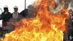 Pengunjuk rasa berdiri dengan perisai di sekitar barikade yang terbakar selama protes anti-pemerintah di Bogota, Kolombia (28/5/2021). Warga Kolombia telah turun ke jalan selama berminggu-minggu setelah pemerintah mengusulkan kenaikan pajak. (AP Photo/Ivan Valencia)