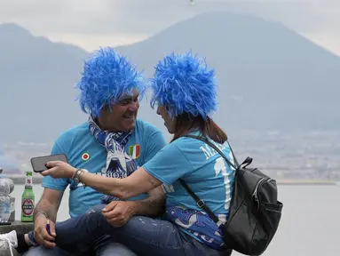 Sepasang fans Napoli bersukacita diluar stadion setelah tim kesayangannya mencetak gol ke gawang Salernitana pada menit ke-62. (AP Photo/Gregorio Borgia)