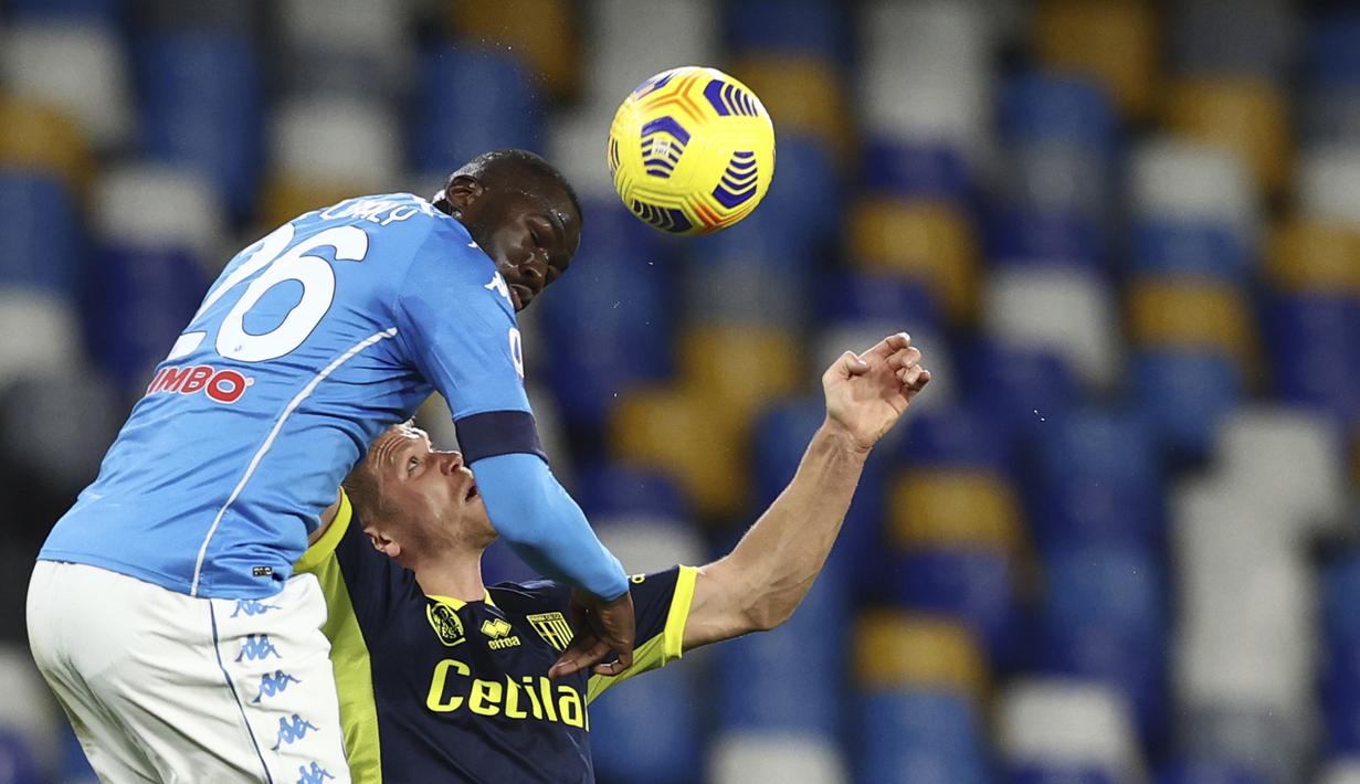 Bek Napoli, Kalidou Koulibaly (kiri) berduel udara dengan striker Parma, Andreas Cornelius dalam laga lanjutan Liga Italia 2020/21 pekan ke-20 di Diego Armando Maradona Stadium, Minggu (31/1/2021). Napoli menang 2-0 atas Parma. (LaPresse via AP/Alessandro Garofalo)