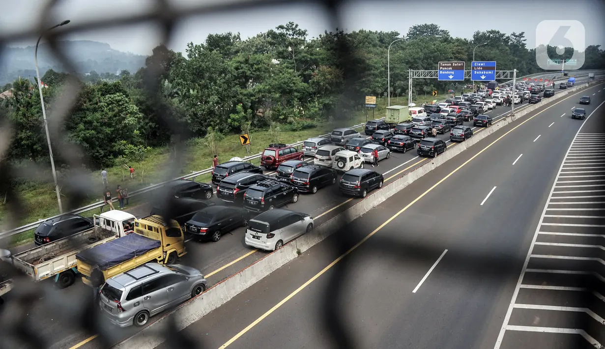 Kendaraan wisatawan terjebak penutupan jalur Puncak akibat sistem satu arah di Tol Jagorawi, Pandansari, Bogor, Jawa Barat, Minggu (19/9/2021). Polres Bogor menutup sementara jalur arah Puncak Pass seiring pemberlakuan sistem satu arah kendaraan dari Puncak ke Jakarta. (merdeka.com/Iqbal S. Nugroho)