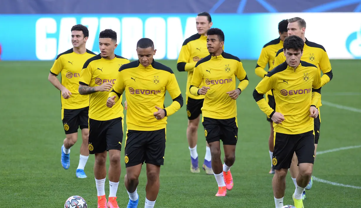 Para pemain Borussia Dortmund melakukan pemanasan saat mengikuti sesi latihan di stadion Ramon Sanchez Pizjuan di Seville (16/2/2021). Dortmund akan bertanding melawan Sevilla pada leg pertama babak 16 besar Liga Champions. (AFP/Cristina Quicler)
