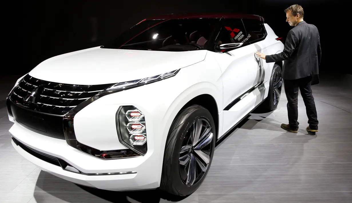 Seorang jurnalis melihat Mitsubishi GT PHEV Concept saat ditampilkan di Paris Auto Show di Paris, Prancis (29/9). (REUTERS/Benoit Tessier)