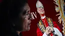 Seorang wanita berdiri di samping gambar Robert Francis Prevost, yang menjadi Paus Leo XIV pada tanggal 8 Mei 2025, di depan katedral Chiclayo di utara Lima pada hari pemilihannya sebagai paus ke-267 Gereja Katolik. (ERNESTO BENAVIDES/AFP)