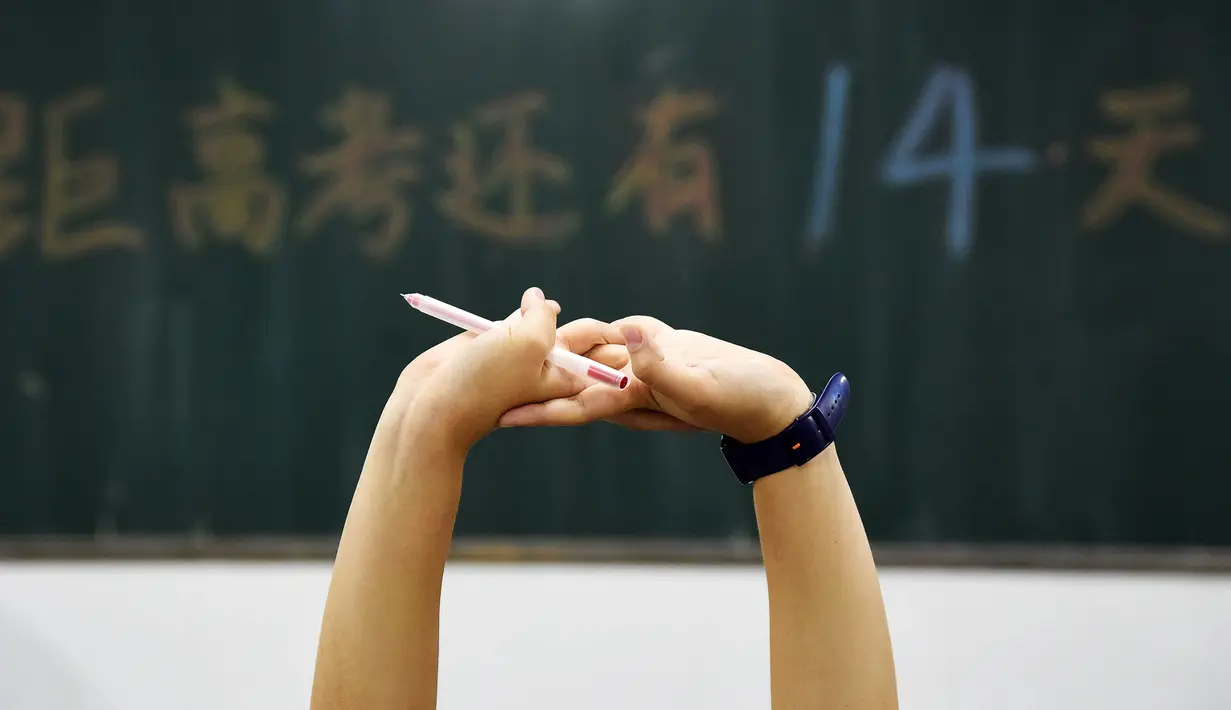 Siswa sekolah menengah bersiap mengisi soal menjelang ujian tahunan "Gaokao" atau ujian masuk perguruan tinggi di China, provinsi Hebei utara (23/5). Gaokao dikenal oleh para siswa di China sebagai ujian tersulit selama sekolah. (AFP Photo/China Out)
