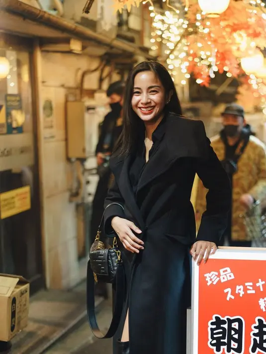 <p>Ia memakai maxi coat, kemeja, short, dan boots tinggi sepaha, serta menjinjing tas berwarna hitam. (Foto: IG @kiranalarasati)</p>
