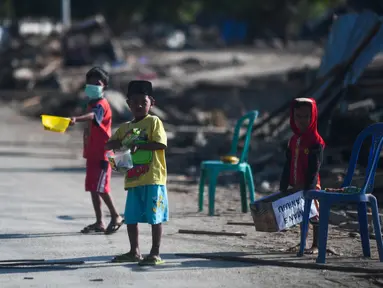 Anak-anak yang terkena dampak gempa meminta sumbangan pada pengguna jalan yang melintas di Donggala, Sulawesi Tengah, Jumat (5/10). Akibat terlambatnya pasokan bantuan, mereka terpaksa meminta sumbangan hingga turun ke jalan. (AFP PHOTO / Jewel SAMAD)