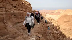  Para wisatawan saat menaiki puncak daerah Naqba Rum di Sinai Selatan, Mesir, (20/11). Kegiatan ini dilakukan untuk mengampanyekan bahwa suku Badui Mesir aman dan tempat ini layak untuk dikunjungi. (REUTERS/Asmaa Waguih)
