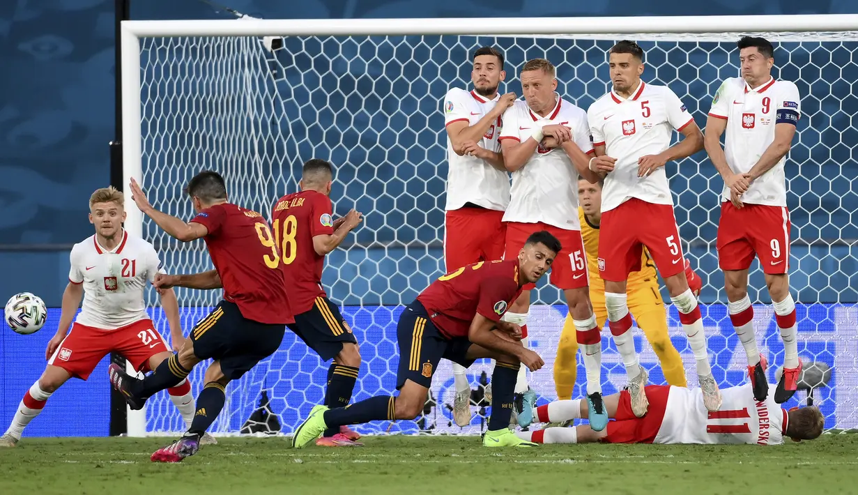 Spanyol berpeluang menambah gol lewat tendangan bebas yang dilepaskan striker Gerard Moreno (kiri) pada menit ke-34. Sepakannya berhasil melewati pagar betis Polandia, namun masih melebar di sisi kanan gawang Wojciech Szczesny. (Foto: AP/Pool/Lluis Gene)