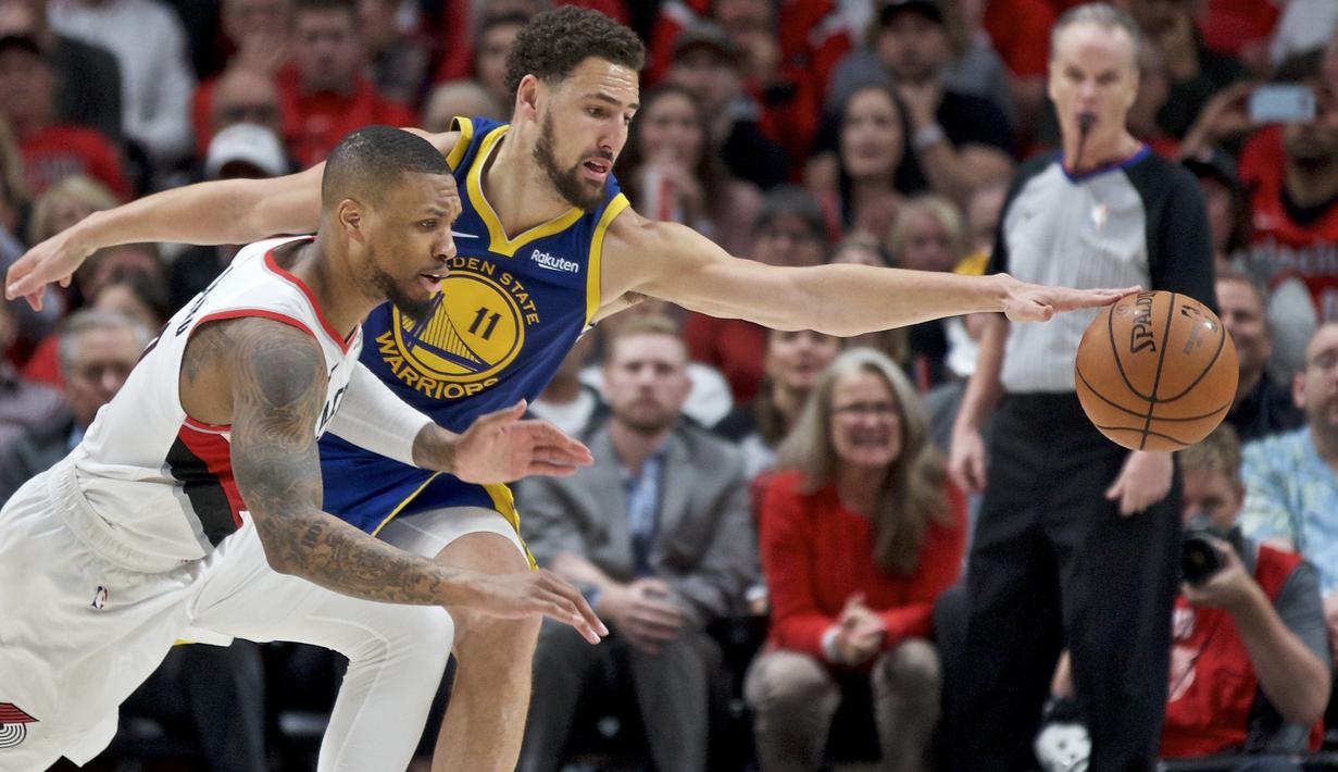 Pebasket Golden State Warriors, Klay Thompson, berebut bola dengan pebasket Portland Trail Blazers, Damian Lillard, pada laga NBA 2019 di Moda Center, Senin, (20/5). Warriors menang 119-117 atas Blazers. (AP/Craig Mitchelldyer)