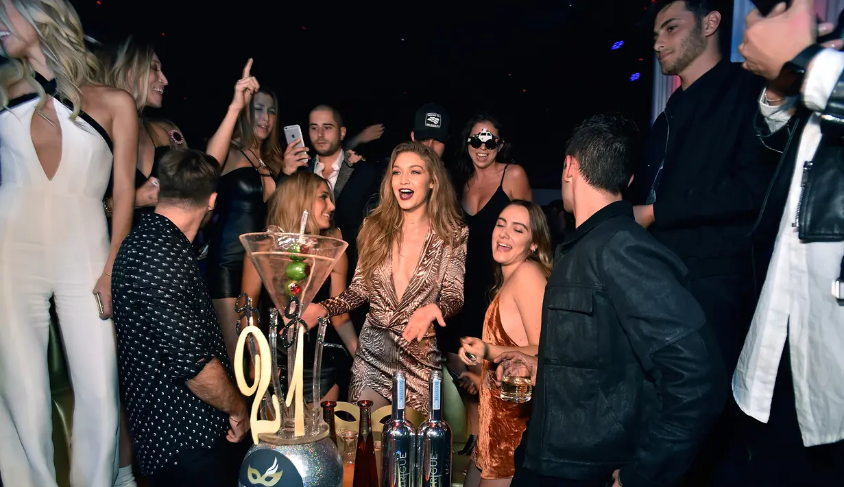 Model Gigi Hadid (tengah) bergembira merayakan ulang tahunnya yang ke-21 dengan teman-teman di Intrik Nightclub di Wynn Las Vegas, Nevada ( 30/4). Mengenakan mini dress berwarna coklat gigi hadid tampak seksi dan cantik. (AFP PHOTO/David Becker)