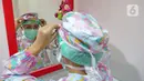 dr. J. Mila Hardiani C merapikan tutup kepala di ruang poli anak  di RSIA Tambak, Jakarta, Kamis (18/6/2020). Dokter menggunakan APD lengkap bertujuan untuk memberikan kenyamanan kepada anak-anak yang menjalani pemeriksaan juga guna mengantisipasi penularan COVID-19. (Liputan6.com/Herman Zakharia)