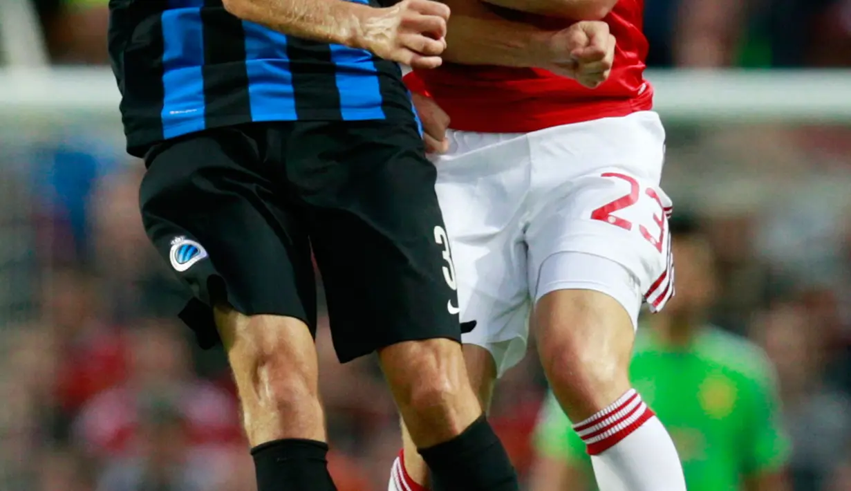 Bek  MU Luke Shaw beradu bola udara dengan Timmy Simons dalam pertandingan kualifikasi UEFA Champions League leg pertama di Old Trafford, Manchester , Inggris, Selasa (18/8/2015).  Gol dicetak oleh Memphis Depay dan Fellaini. (Reuters/Jason Cairnduff)
