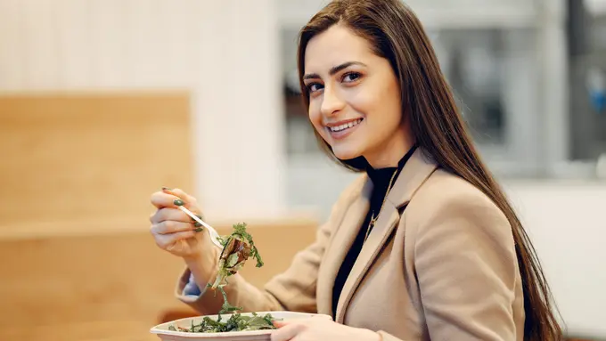Seorang perempuan makan sayuran (Foto Dok: Freepik/prostooleh)