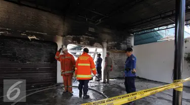 Petugas pemadam melakukan upaya pendinginan kebakaran kios bengkel ac mobil di kawasan Hj. Nawi, Jakarta, Senin (20/7/2015). Pemadam kebakaran mengerahkan 13 unit mobil Damkar di tempat kejadian kebakaran. (Liputan6.com/Helmi Afandi)