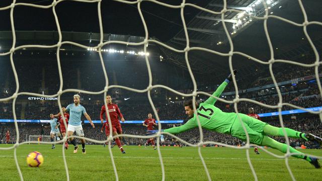 Kiper Liverpool, Alisson Becker, gagal menepis tendangan gelandang Manchester City, Leroy Sane, pada laga Premier League di Stadion Etihad, Manchester, Kamis (4/1). City menang 2-1 atas Liverpool. (AFP/Oli Scarff)
